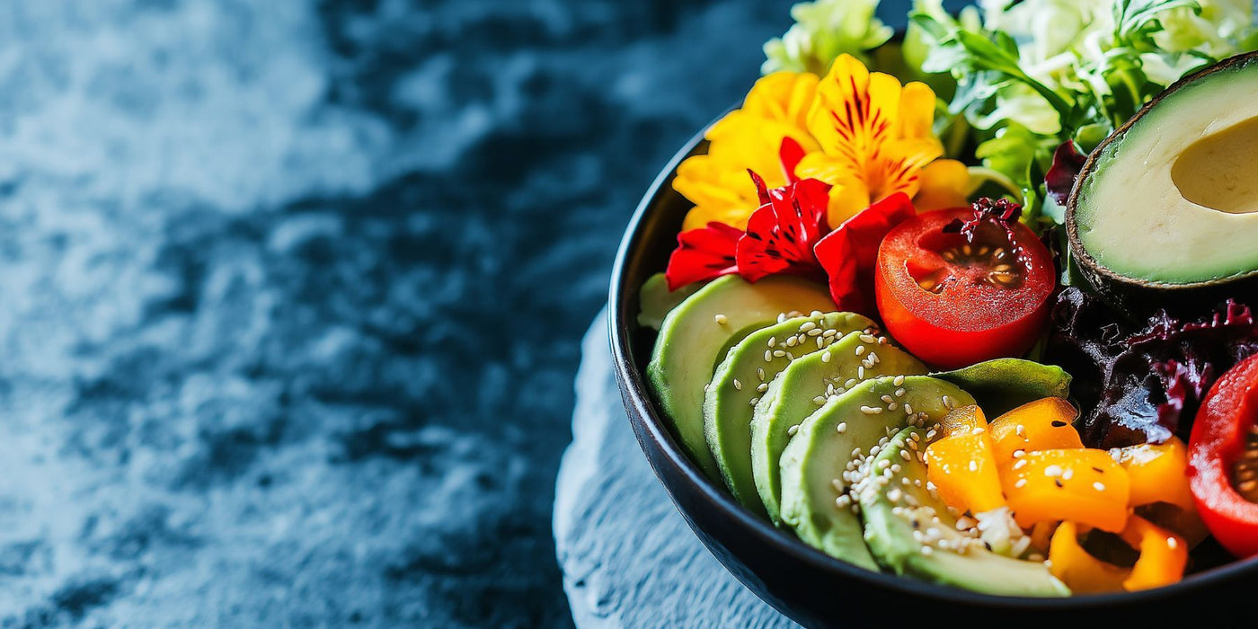 Colorful nourishing salad bowl with avocado slices tomato yellow peppers sesame seeds and edible flowers
