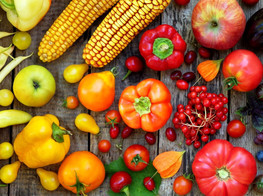 Colorful assortment of fresh fruits and vegetables spread on a rustic wooden surface