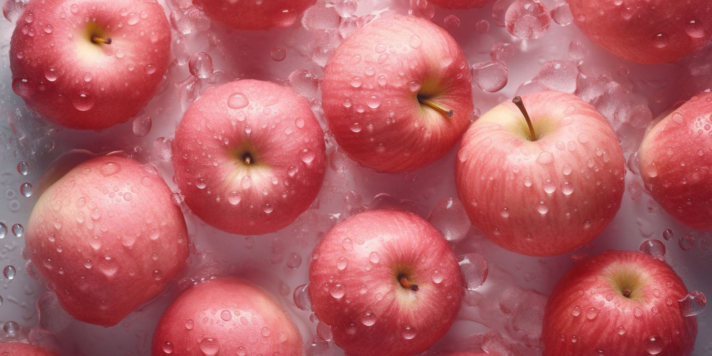 Fresh red apples with water droplets resting on ice.