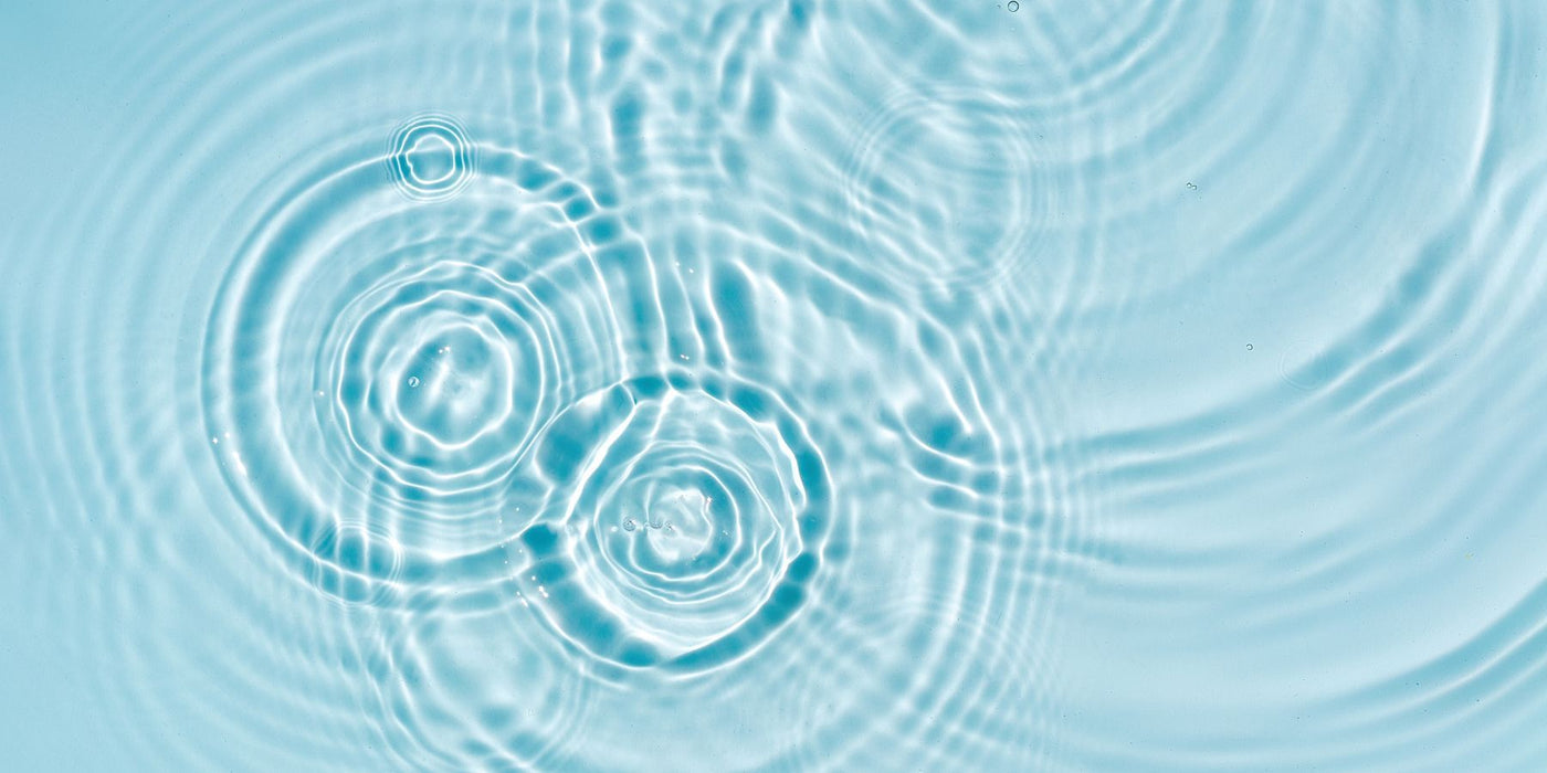Underwater view with rippled light on a rocky seafloor under bright blue water