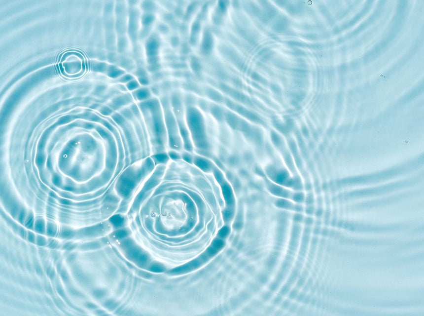 Underwater view with rippled light on a rocky seafloor under bright blue water