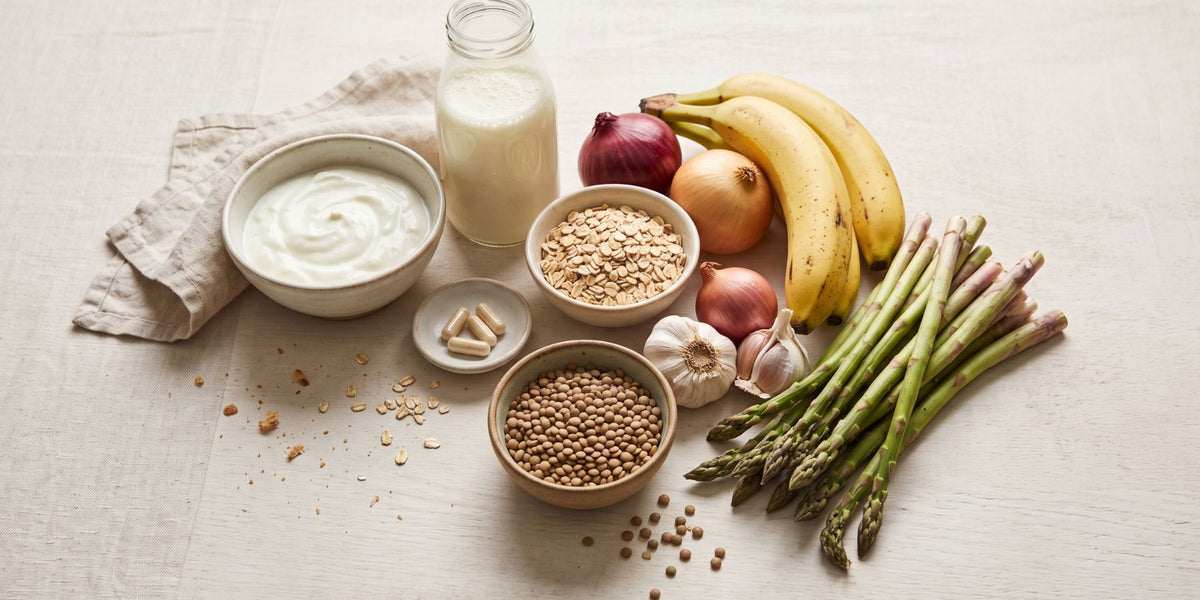 Fibre-rich foods including wholegrains, fruit, vegetables, lentils, nuts and seeds alongside yoghurt representing prebiotics, probiotics and gut health.