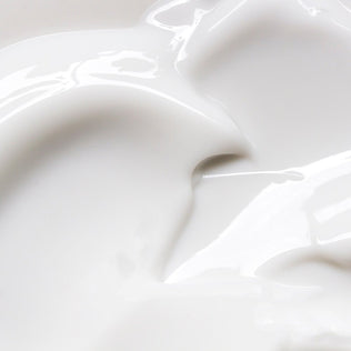 Glossy white cream texture close up on a smooth surface